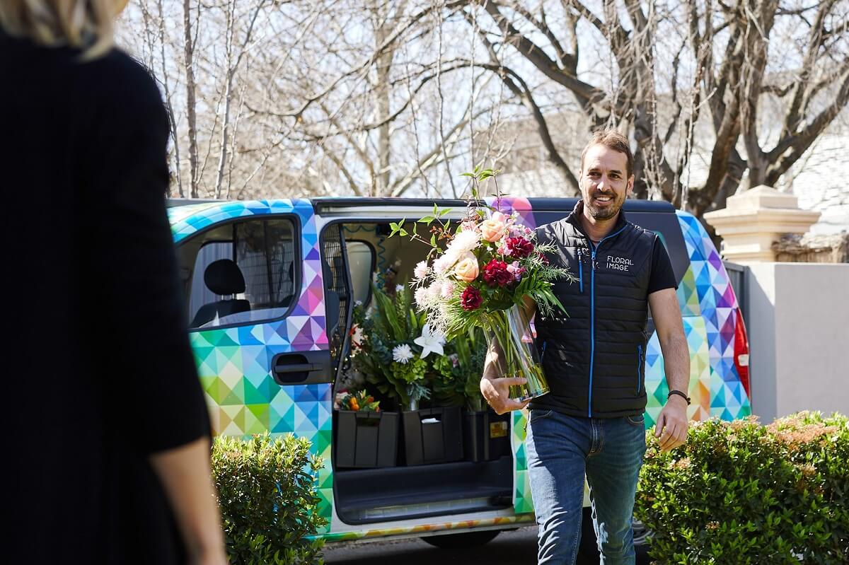 Floral Images Man Franchisee in front of van holding flowers