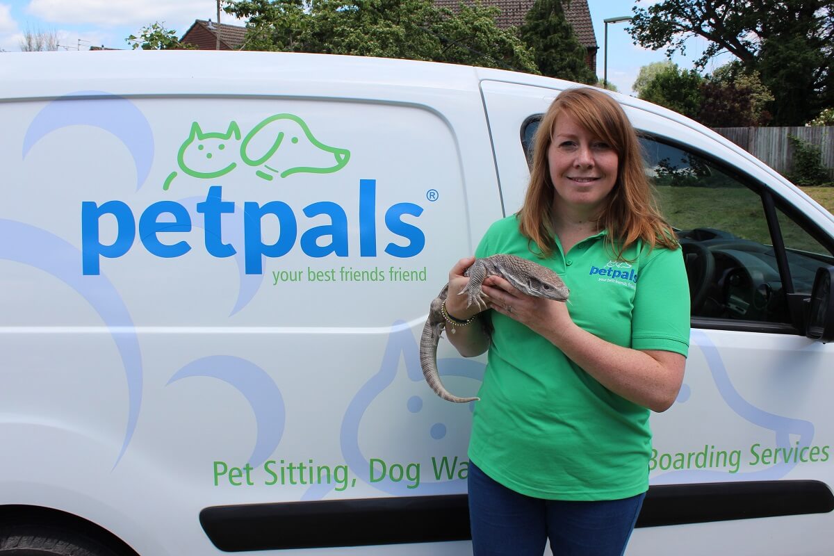 Petpals franchise holding a lizard beside a van