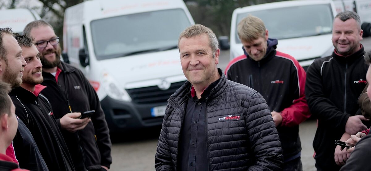 Revive Auto Innovations Franchisees standing in front of a row of vans