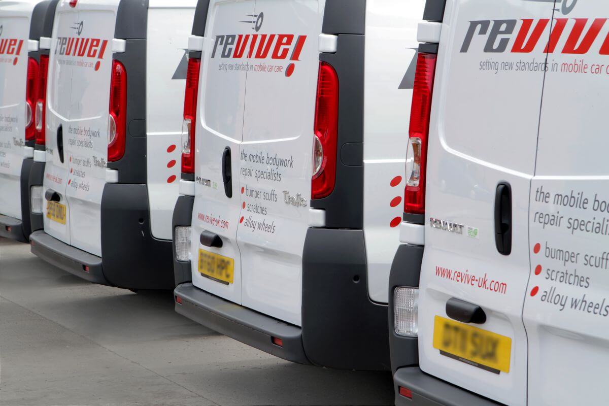 Revive Auto Innovations Franchisees standing in front of a row of vans