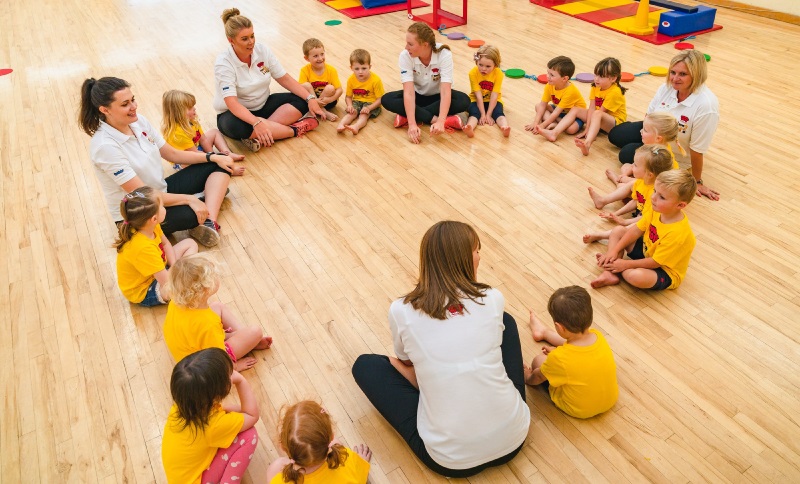 Children sitting in a circle in their Tumble Tots class