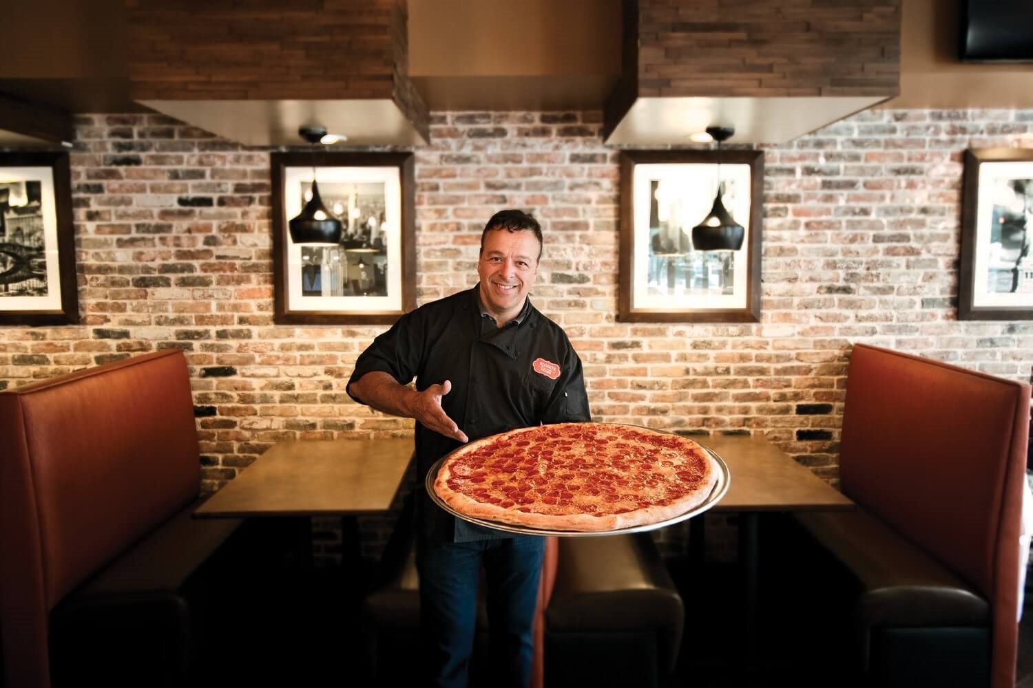 russos founder anthony holding pizza